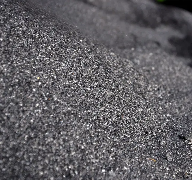 Large-format slabs of graphite-black granite are split by hand directly at the quarry: the texture of each slab and the pattern of each face are unique.